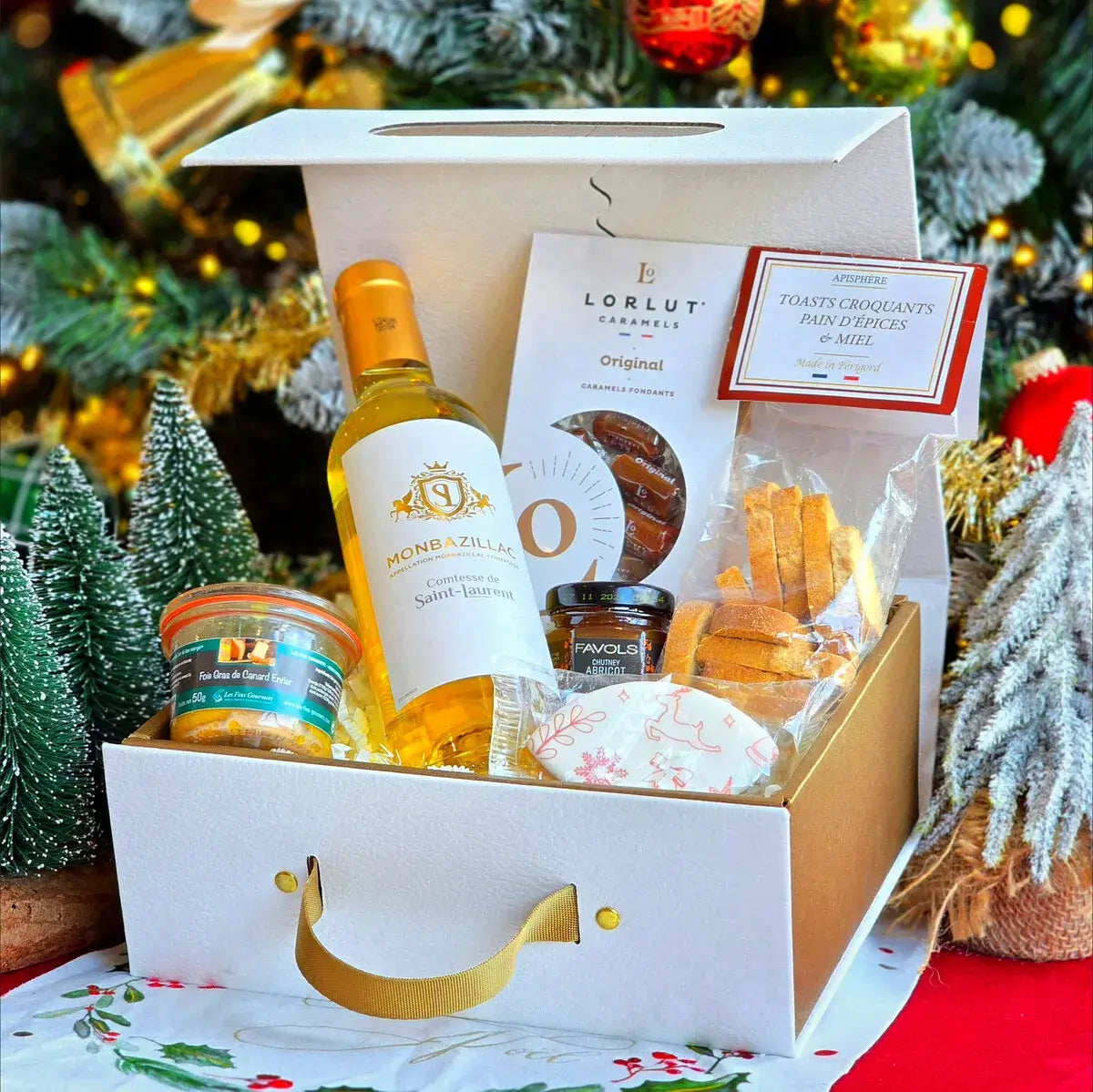Cadeaux de Noël pour la maison : bougie, plaid, lampe et plante en pot disposés près d'un sapin