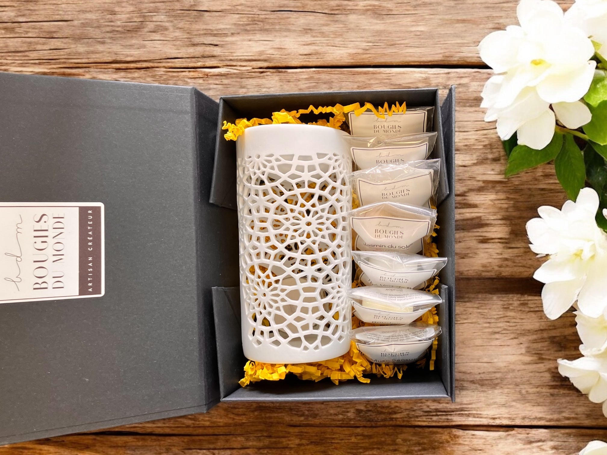 Coffret de bougies parfumées et accessoires posés sur une table pour un amateur de bougies